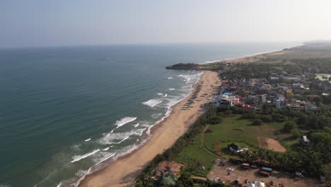 Aerial-Sunset-Shot-of-Seashore-filled-with-Boats-near-Mahabalipuram-temple