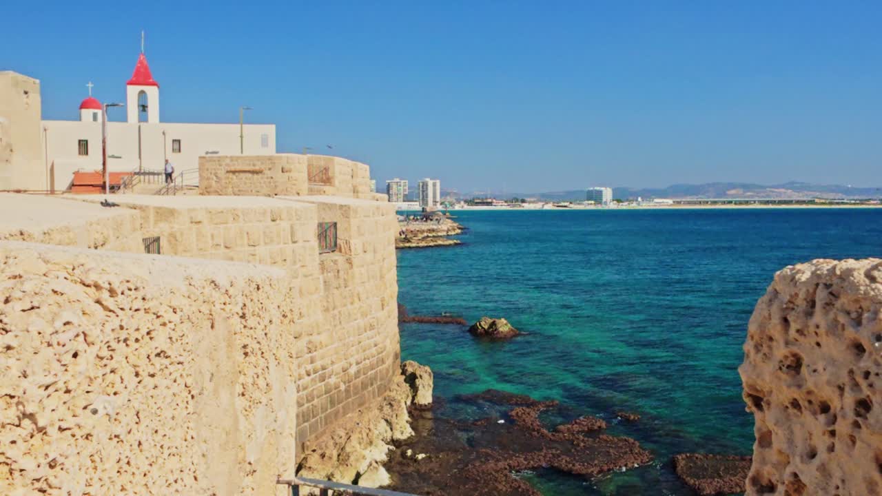Bird flying past the ancient sea walls of the Old City of Acre