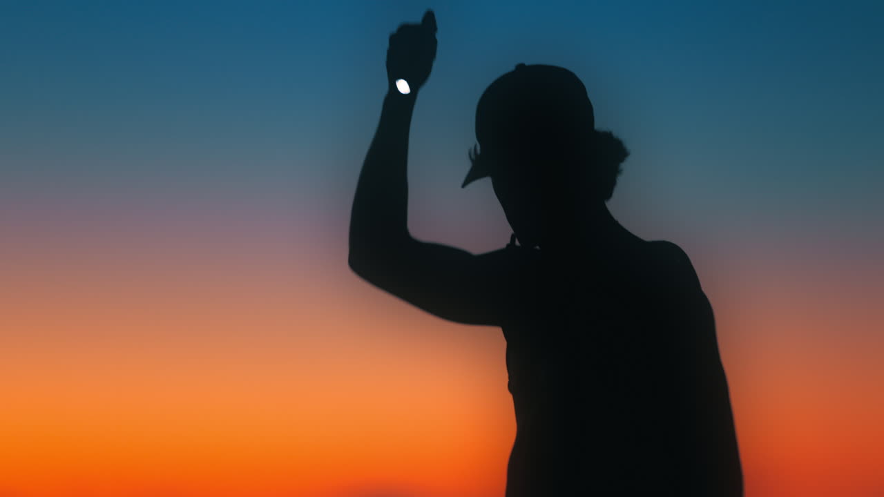 Hiker shines flashlight around during sunset creating a chromatic flare. Shot on Canon R5 4k Fine with RF 70-200mm f2.8 with chromatic flare filter.