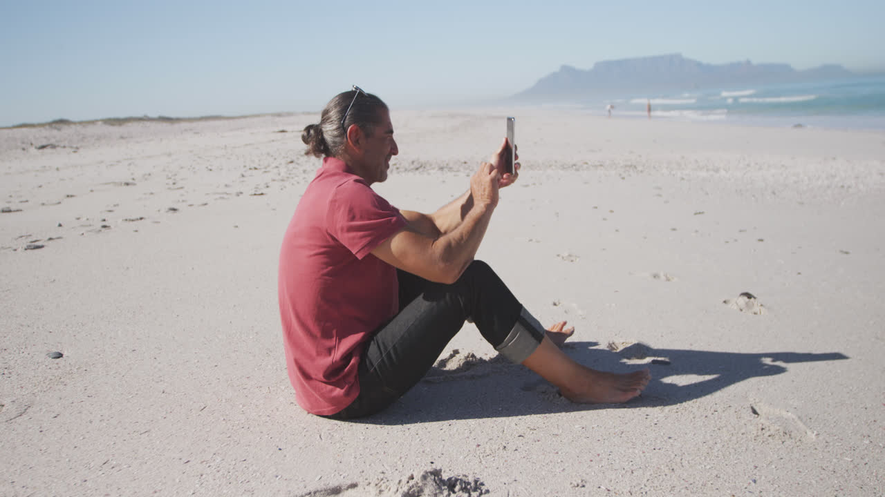 Senior Caucasian man using a digital tablet on the beach