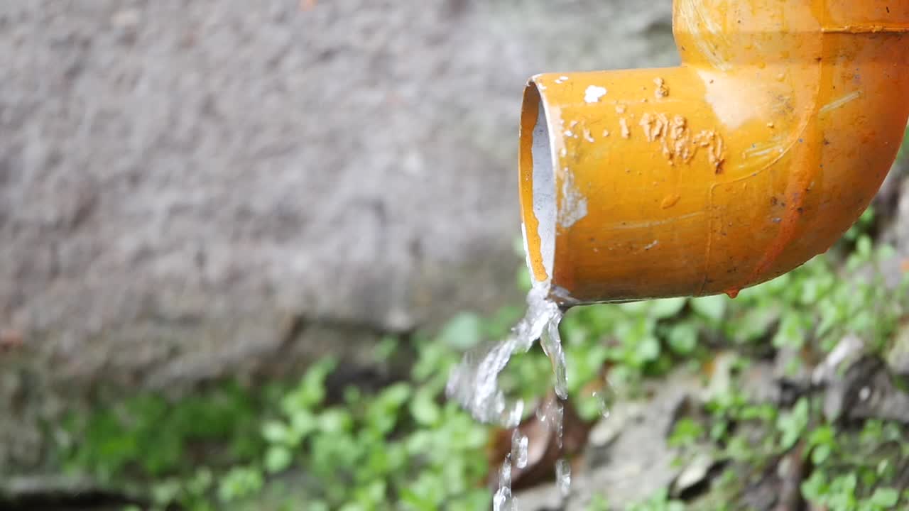 Water Draining from a Yellow Gutter