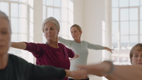 Yoga-Kurs-Mit-Gesunden,-Reifen-Frauen,-Die-Kriegerpose-Praktizieren-Und-Das-Morgendliche-Körperliche-Fitnesstraining-Im-Studio-Genießen