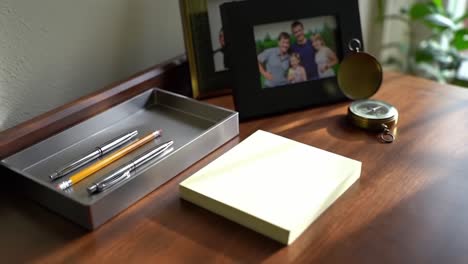 a tranquil workspace scene featuring organized stationery items including pens and a notepad surrounded by personal touches and natural lighting