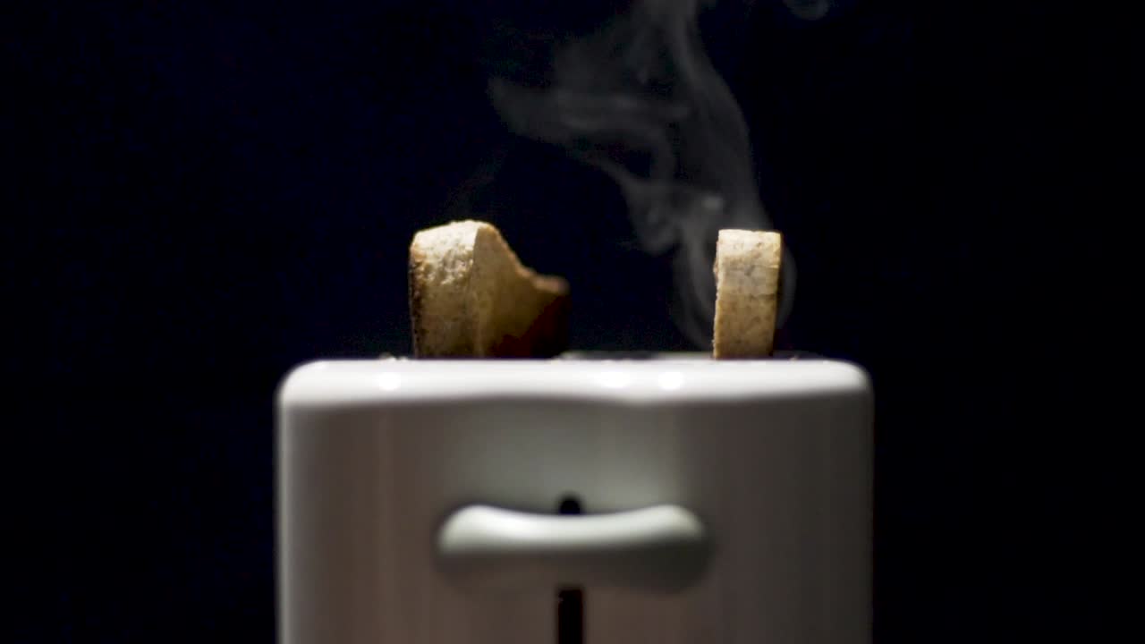 검은 배경을 가진 토스터에서 터지는 토스트의 슬로우 모션 클로즈업 샷