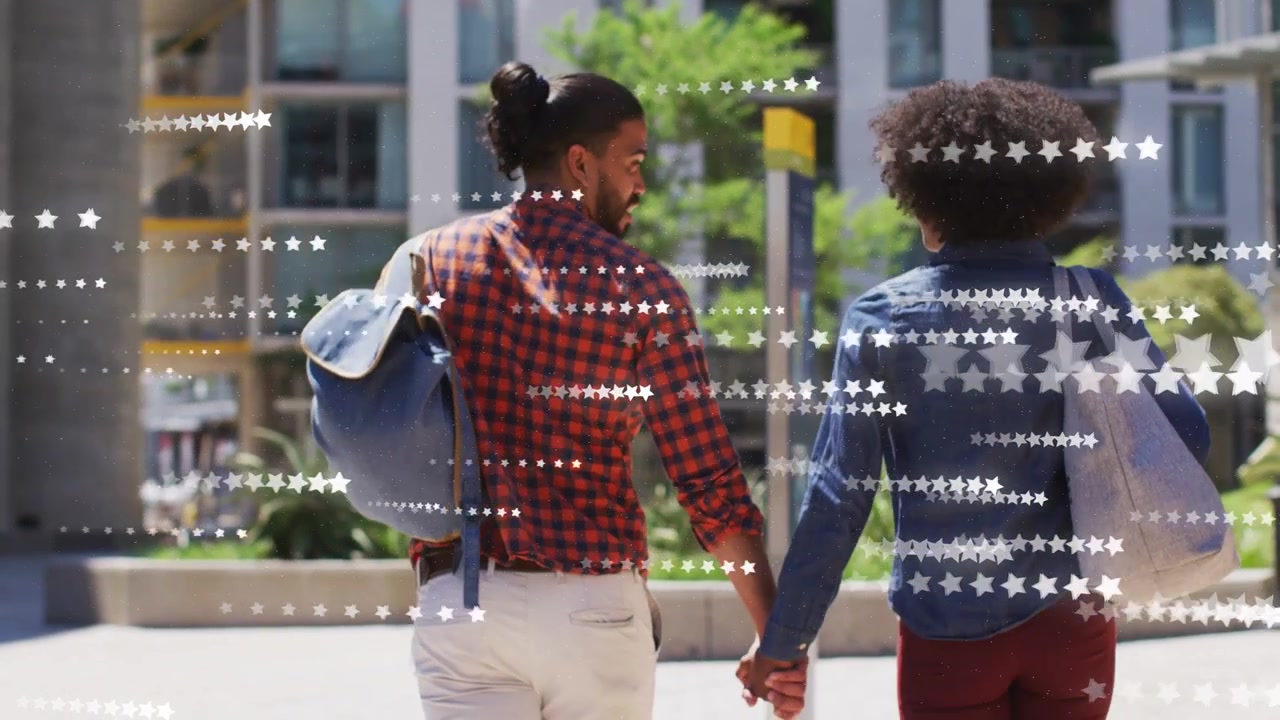 Pair starting walk in plaza holding hands heading to blocks as star overlay obscuring frame fashion