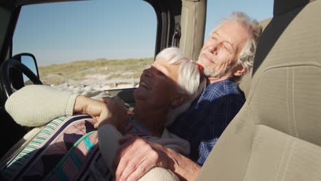 senior couple leaning together in a car