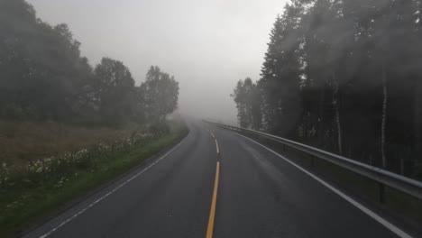 fog on a norway road. pov car trip. vehicle point-of-view driving a car on a road in norway.