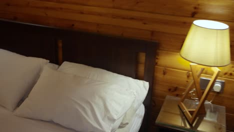 aerial flying backwards into bedroom with double bed and lamp lit