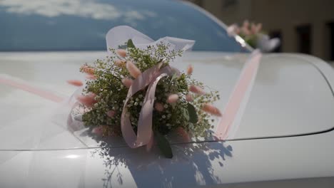 close-up shot of a wedding bouquet and ribbons on the front of a wedding car