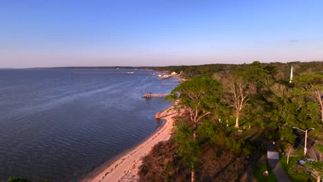 sunset over mobile bay in winter as two kayakers play in the water