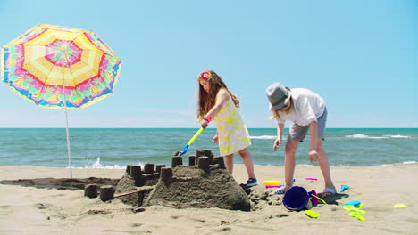 children building sandcastles on the beach