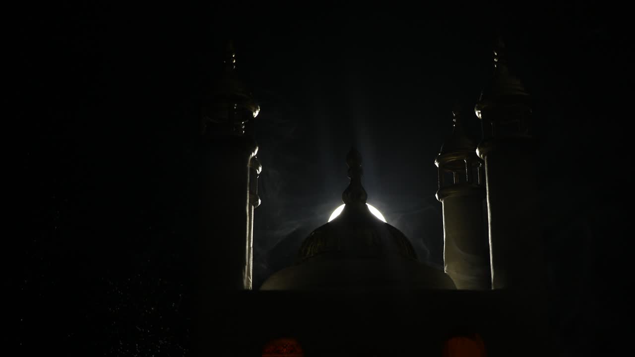 Una miniatura realistica di moschea con finestre illuminate di notte. Biglietto d'auguri festivo, invito per il mese sacro musulmano Ramadan Kareem. Messa a fuoco selettiva.
