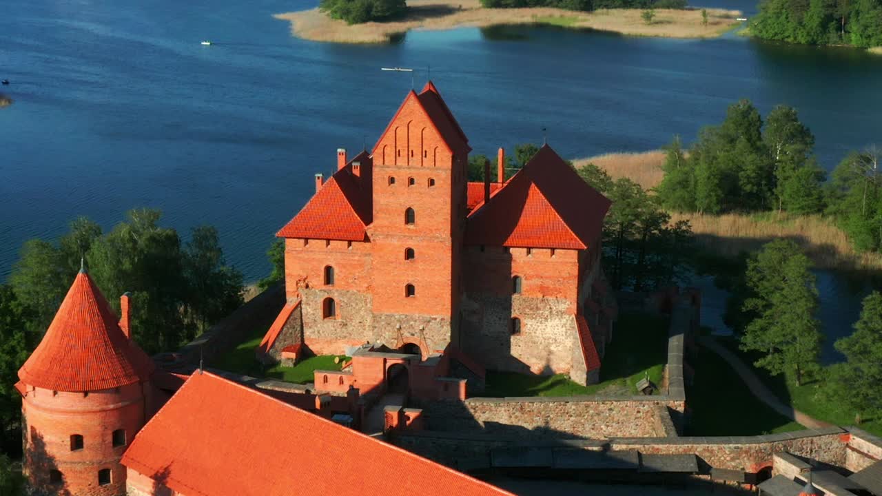 Castello medievale dell'isola di Trakai con mura in pietra e torri nel lago Galvė, Lituania - ripresa aerea.