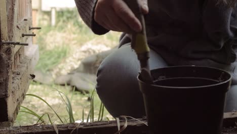 園丁用手<unk>在棚裡將土<unk>轉移到植物盆中