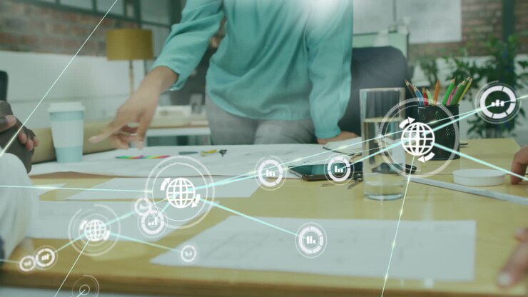 Animation of connected icons over diverse coworkers discussing reports in office