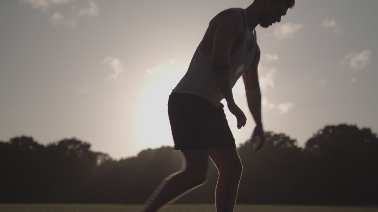 Man Stretchs His Legs In Park Before He Goes For a Run - Ungraded