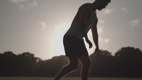 man stretchs his legs in park before he goes for a run - ungraded