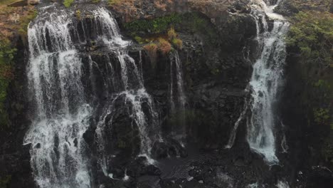 Reveal-shot-of-famous-Tad-Gneuang-Waterfall-at-Laos-during-sunset,-aerial