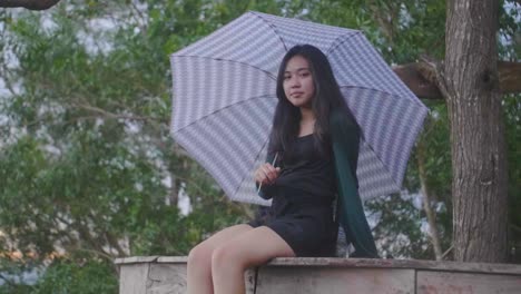 slow motion footage of girl sitting on deck holding an umbrella