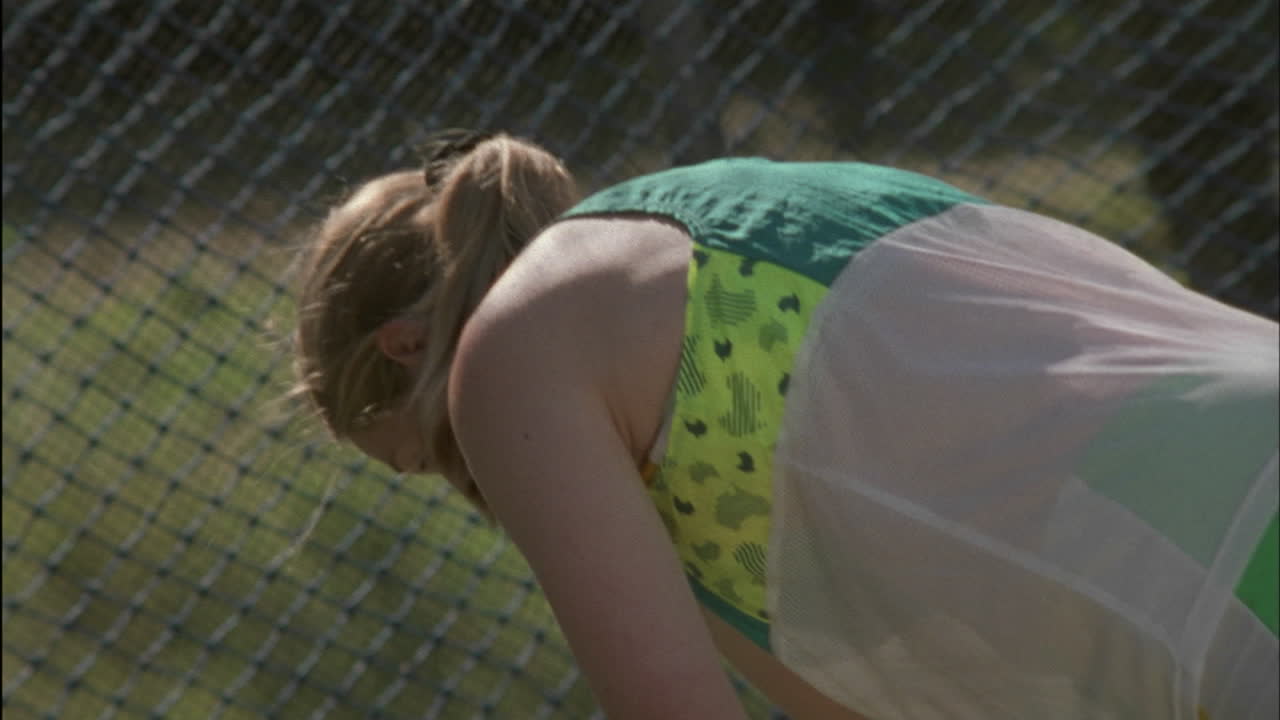 여자가 몸을 숙이고 그네를 타고 공을 던진 후 뒤로 물러서서 돌아서다