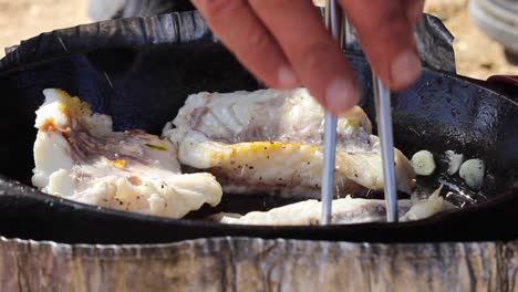 flipping fish fillets on a pan