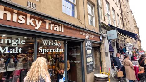 multitudes se reúnen fuera de una tienda de whisky en edimburgo