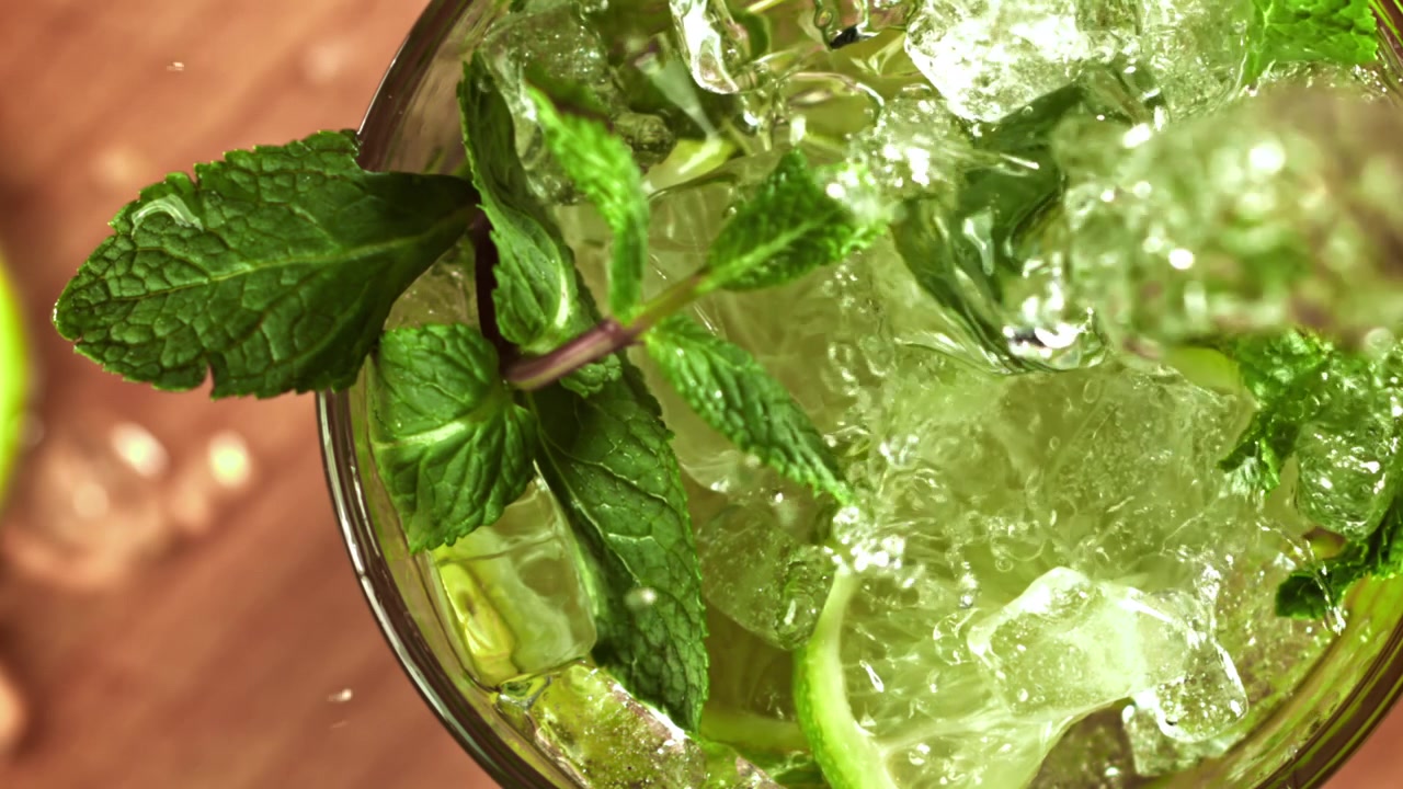 Hidastettu kaato virkistävästä Mojito-cocktailista limellä ja mintulla