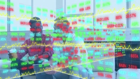 Animation-of-stock-market-data-processing-over-two-diverse-men-discussing-over-a-laptop-at-office