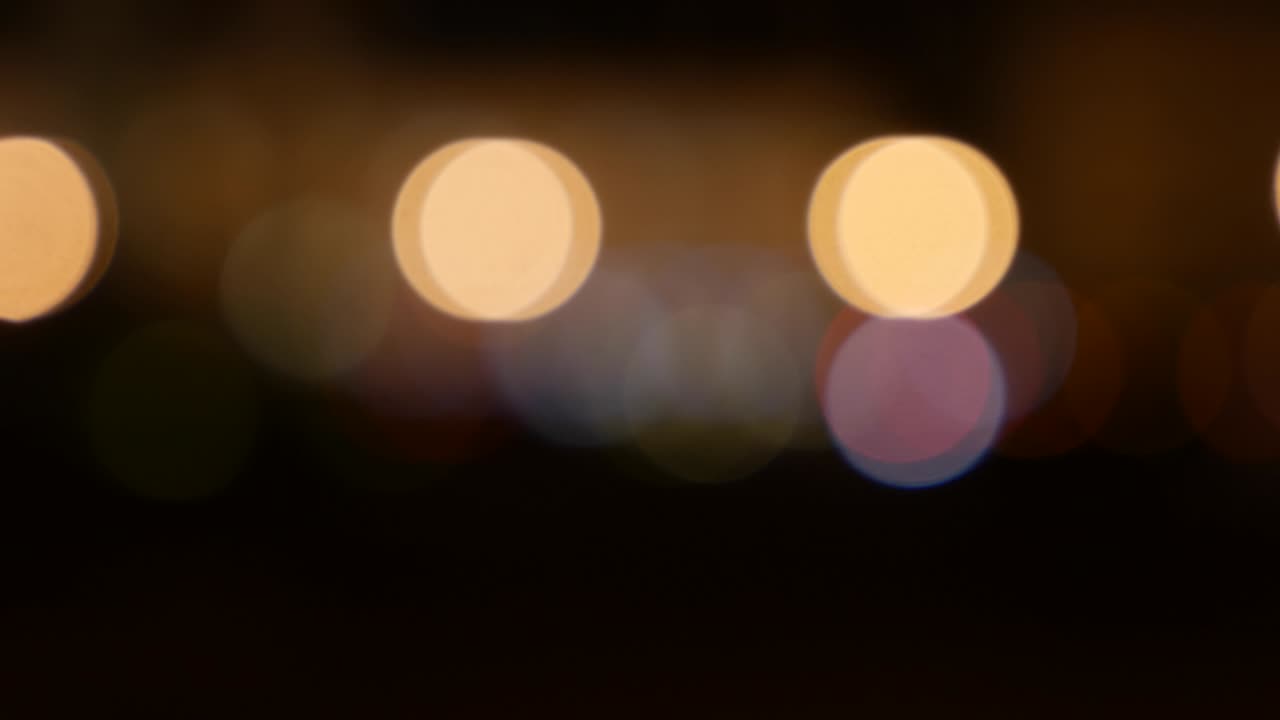 hermoso bokeh brillante en el fondo oscuro borroso por la noche. el redondo bokeh colorido brilla de las luces de los coches en la calle de la ciudad. fuera de foco con borroso. luces de la ciudad sin enfoque. bokeh de tráfico. concepto abstracto