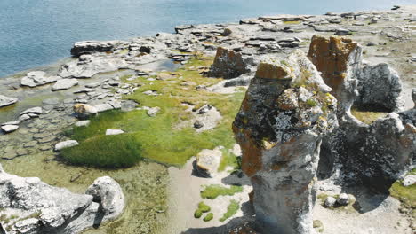 drone orbit around tall sea stacks or rauks, gotland coastline, sweden