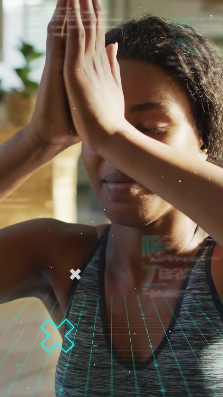 Video verticale: Donna che abbassa le braccia alzate per unire i palmi al centro per lo yoga, guidata da una griglia color verde acqua.