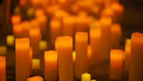 muchas velas encendidas en una habitación oscura durante un evento