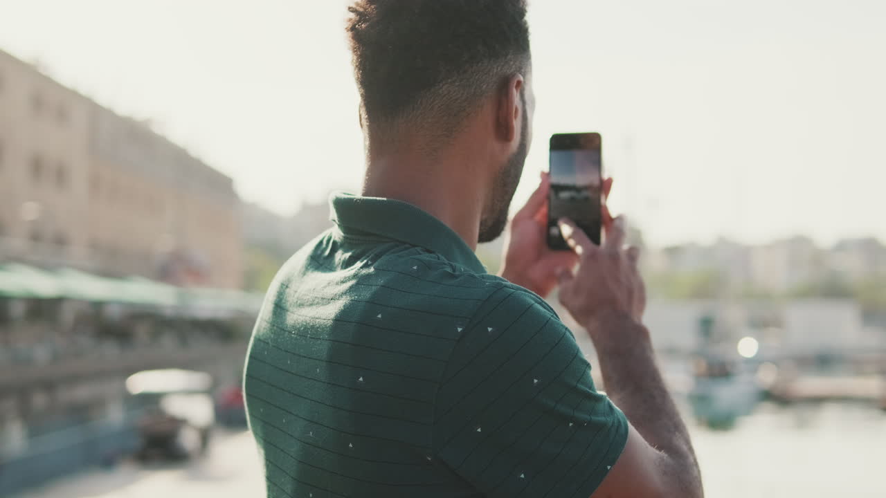 Man taking a photo of the harbor with his phone