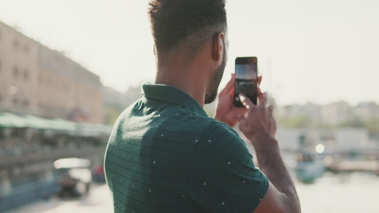 Man taking a photo of the harbor with his phone