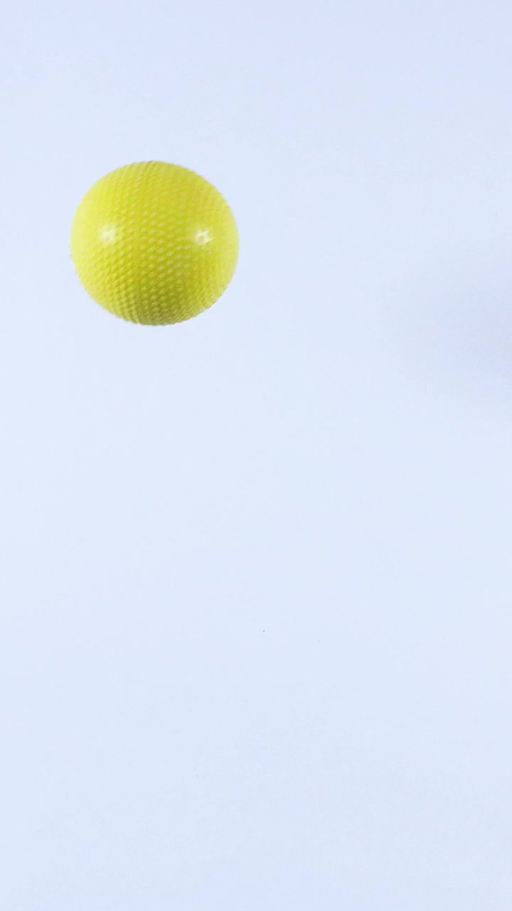 Bola kuning memantul dengan latar belakang putih
