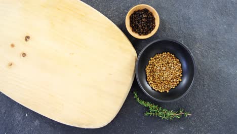 coriander seeds, black pepper, rosemary herbs and wooden board