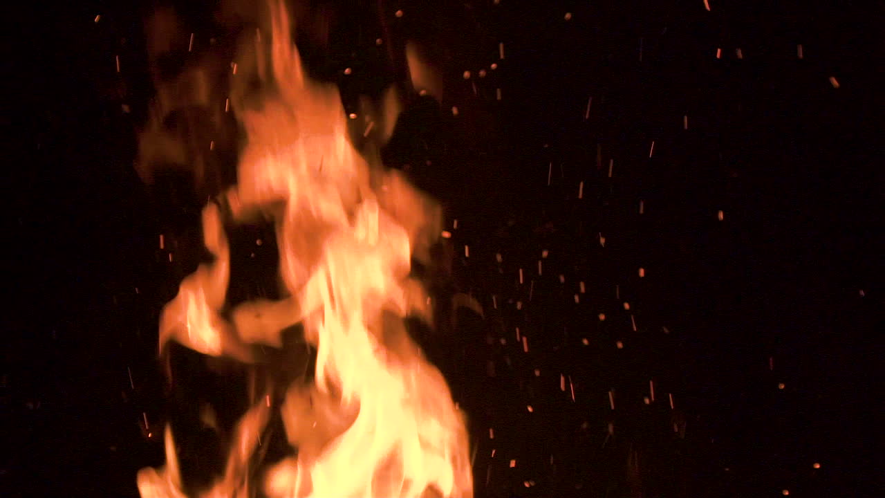 llamas ardientes rojas, naranjas y amarillas aisladas y brasas parpadeando y brillando en fondo negro, cierre estático