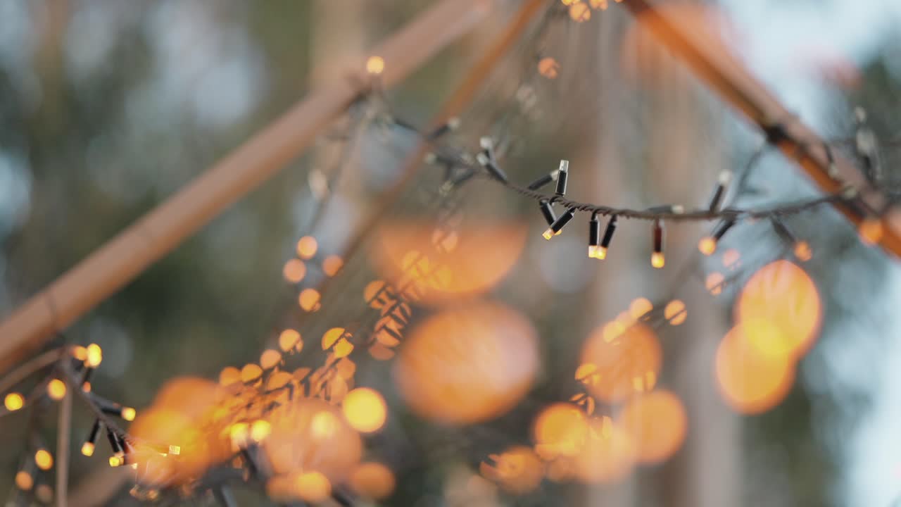 Defocused glowing string lights with warm orange bokeh in outdoor setting