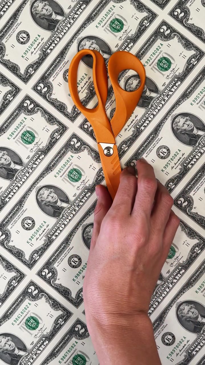 Stack of folded uncut currency sheets. Wealth concept. Several sheets of uncut two-dollar bills folded and stacked together.