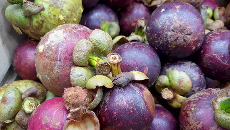 a box of exotic ripe purple mangosteen tropical edible fruit in southeast asia, static closeup