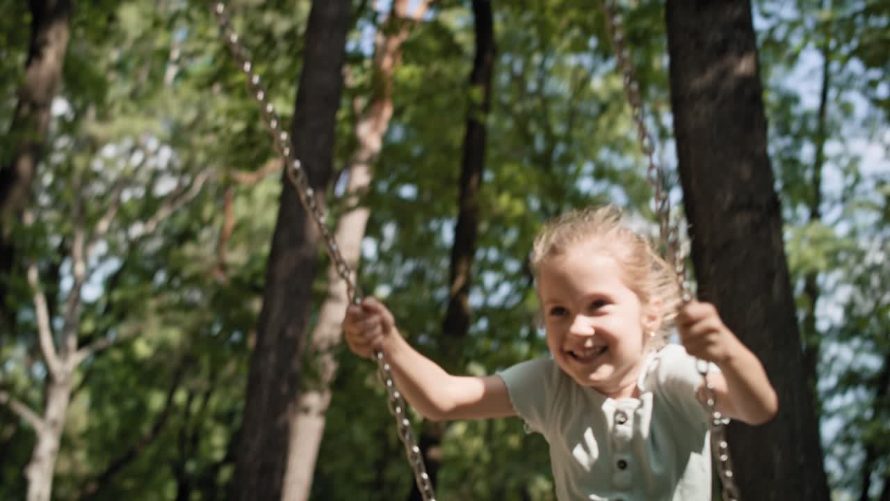 una niña caucásica balanceándose en un día de verano en el parque.