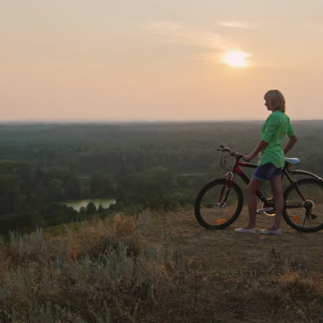 A-woman-admires-the-sunset-during-a-bike-ride