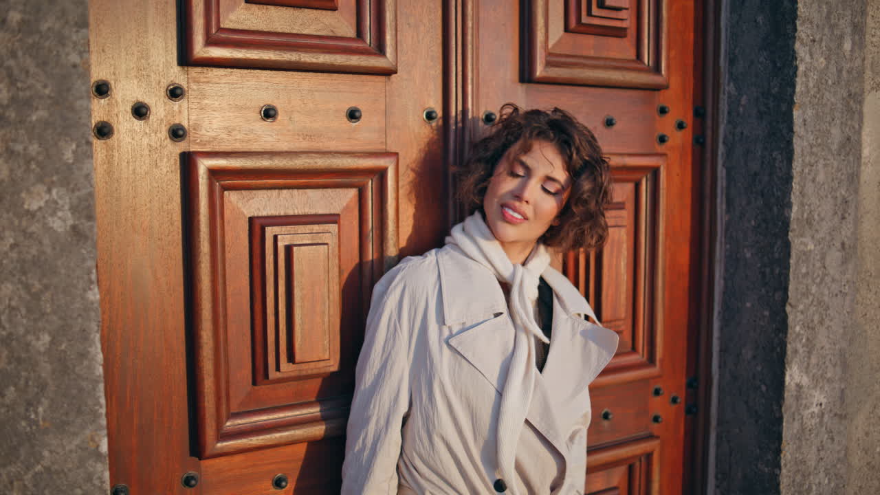 mujer feliz de pie puerta vintage tomando el sol en primer plano. modelo sonriente