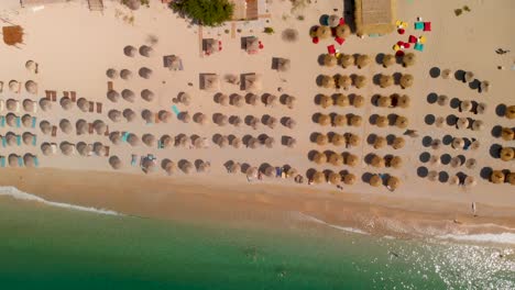 Langsamer-Flug-über-Viele-Sonnenschirme-Und-Wellen-Am-Atemberaubenden-Sandstrand