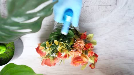 cleaning an artificial flower arrangement in a vase