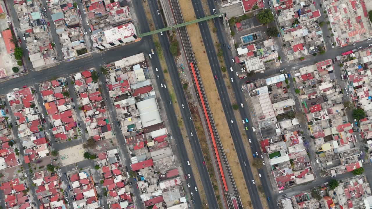 High altitude drone footage showing a busy avenue with vehicle traffic and Mexico City metro in Ecatepec, Mexico