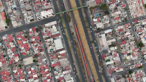high altitude drone footage showing a busy avenue with vehicle traffic and mexico city metro in ecatepec, mexico