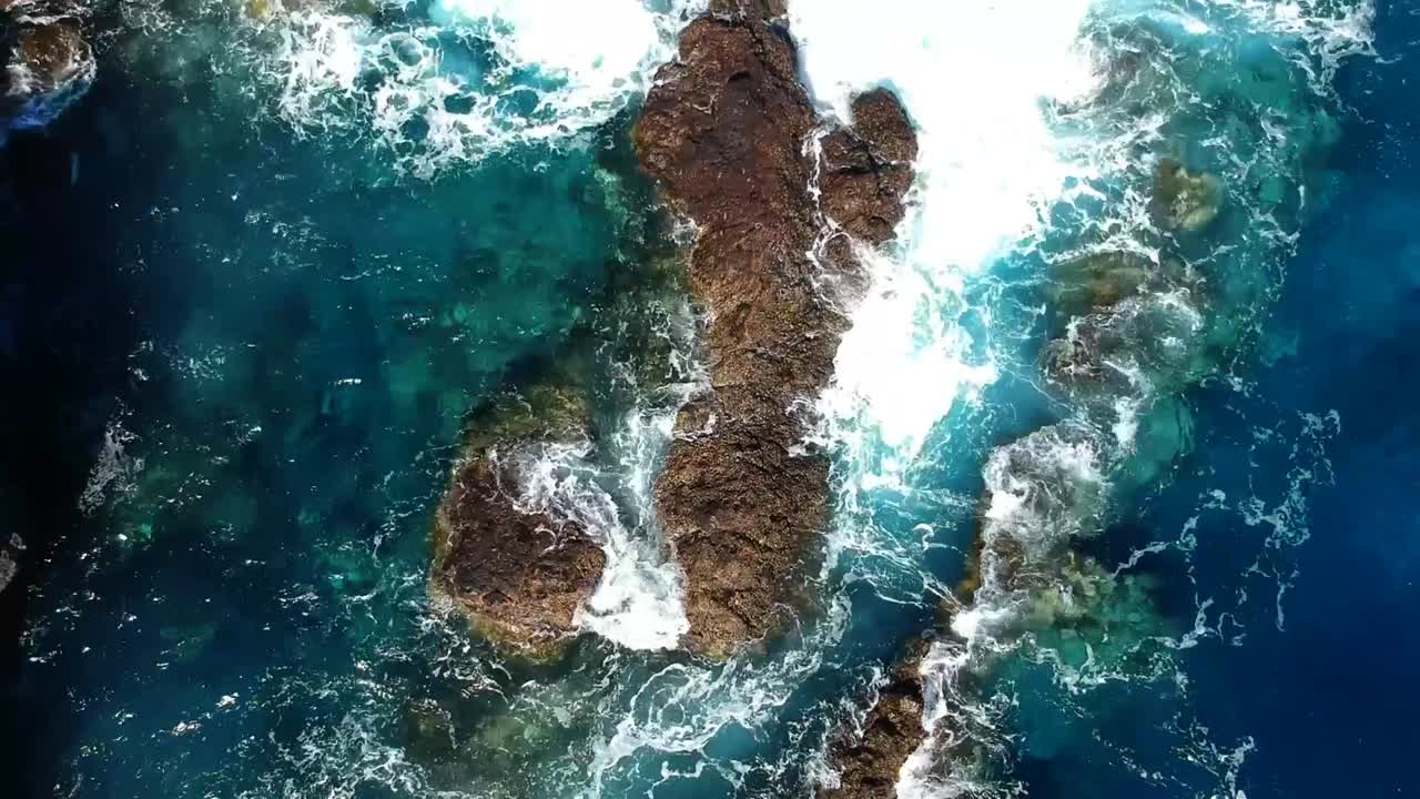 Aeriel drone footage at Garachico - Caleton (Tenerife) next to the blue ocean as the waves hit the rocks in the water