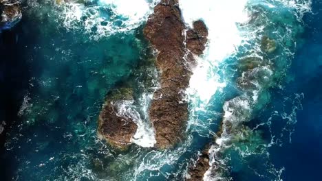 aeriel drone footage at garachico - caleton (tenerife) next to the blue ocean as the waves hit the rocks in the water