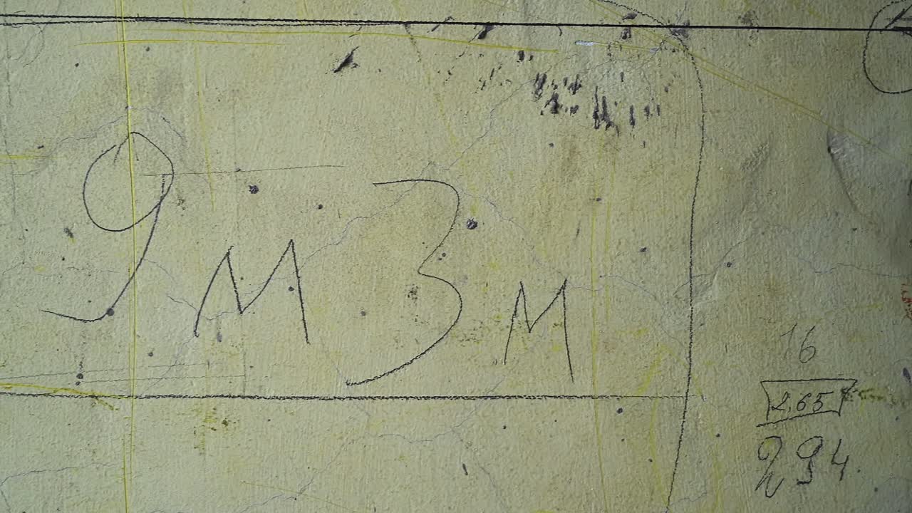 Construction measurements written with chalk on yellow wall